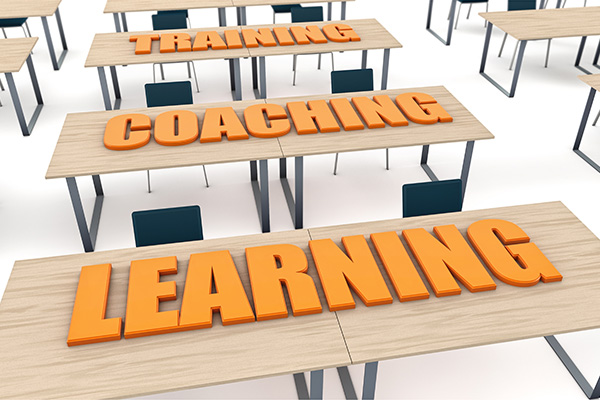Graphic of the words TRAINING, COACHING, and LEARNING on desks