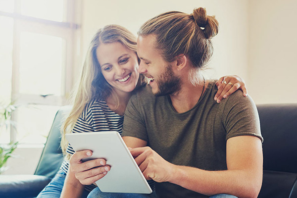 Military student and spouse smile together as they browse options on a tablet