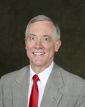 Dr. Ken Tucker is wearing a gray suit with white shirt and bright red tie